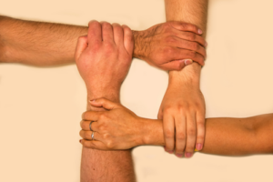 4 people joining wrists to show community